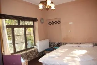 تخت دونفره کنار پنجره در خانه باغ ایرانی