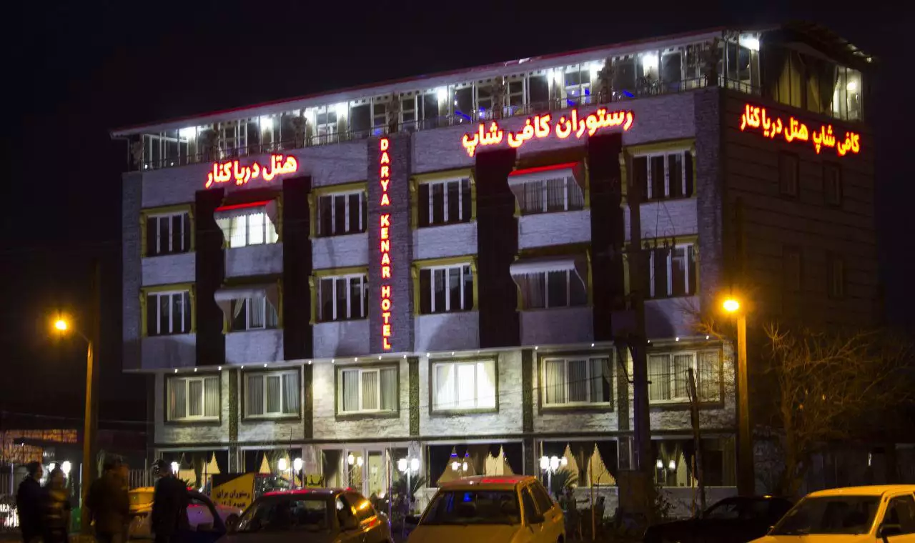نمای شبانه ساختمان هتل دریاکنار و تابلوی روشن رستوران