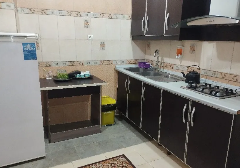 آشپزخانه هتل یاس با کابینت تیره و اجاق گاز