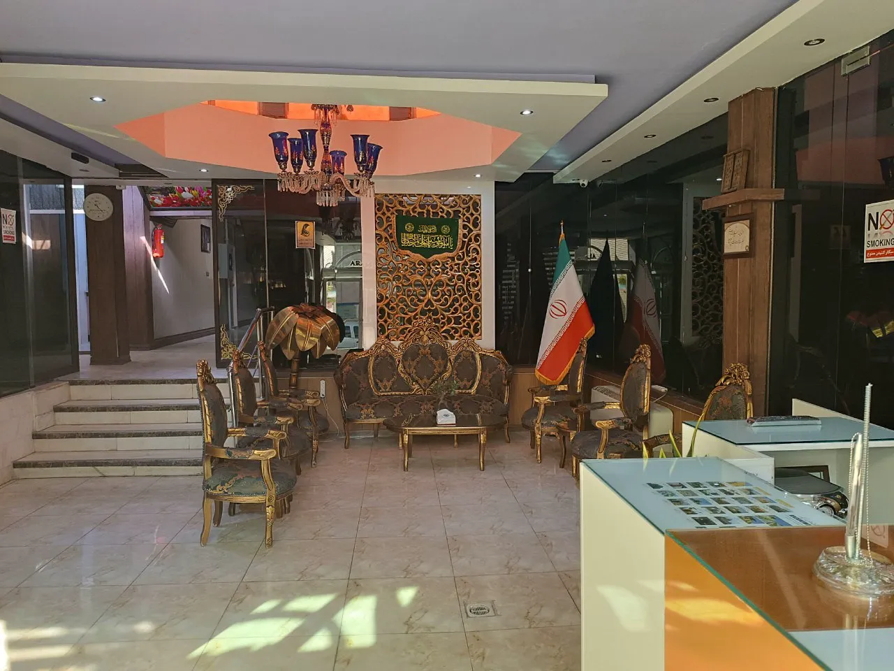 لابی هتل آرام با مبلمان طلایی و پرچم ایران