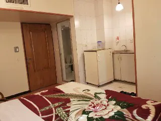 اتاق هتل مروارید با تخت گلدار و یخچال