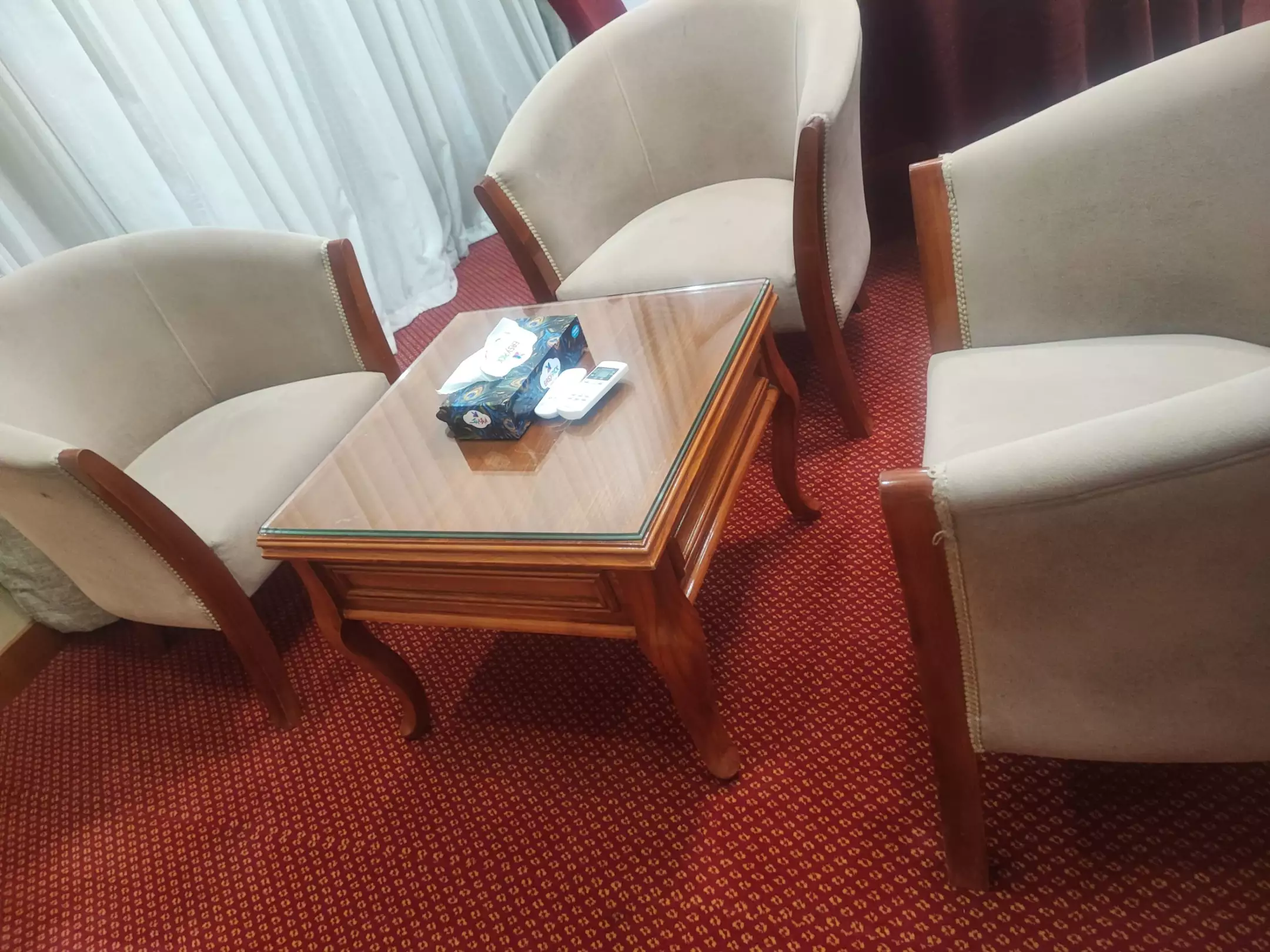 میز چوبی میان صندلی‌های اتاق هتل فردوس