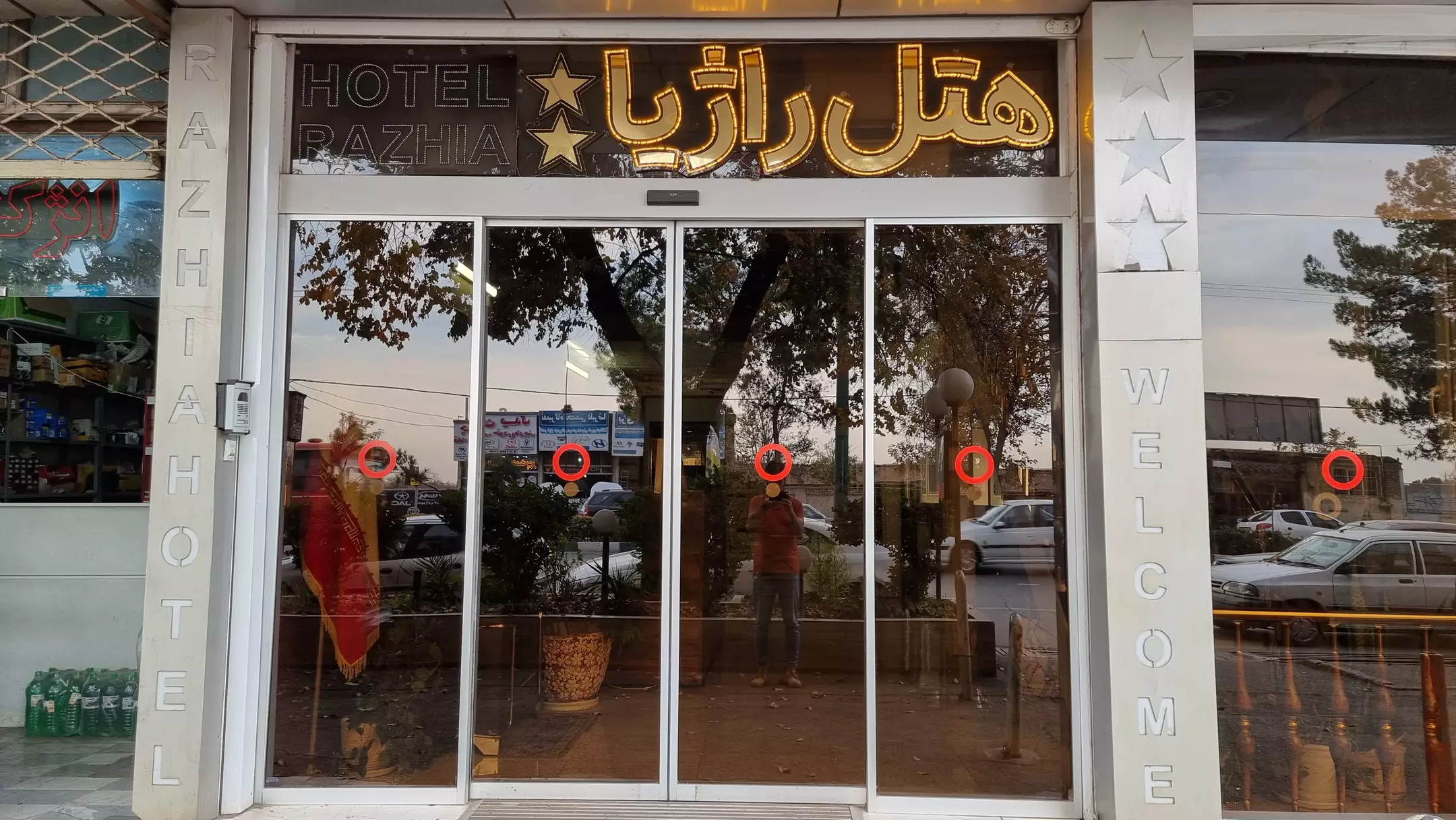 ورودی شیشه‌ای هتل راژیا با تابلوی روشن