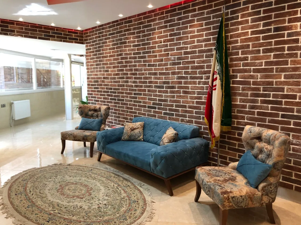 مبلمان آبی و دیوار آجری در لابی هتل راژیا