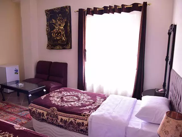 اتاق هتل پلاس با تخت دونفره و مبل