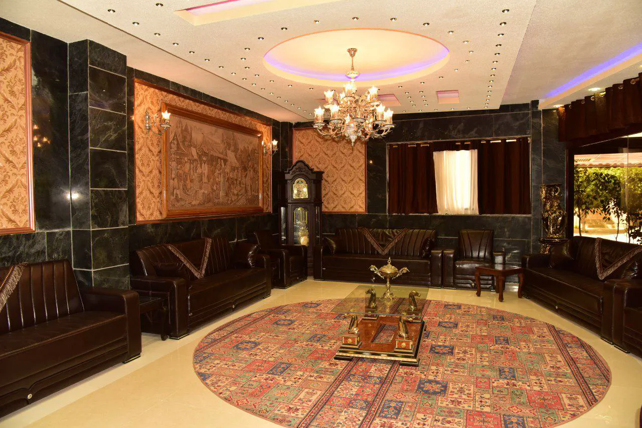 سالن نشیمن با مبلمان چرمی و فرش گرد در هتل پلاس
