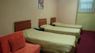 دو تخت یک‌نفره و مبل در اتاق ساحلی پردیس