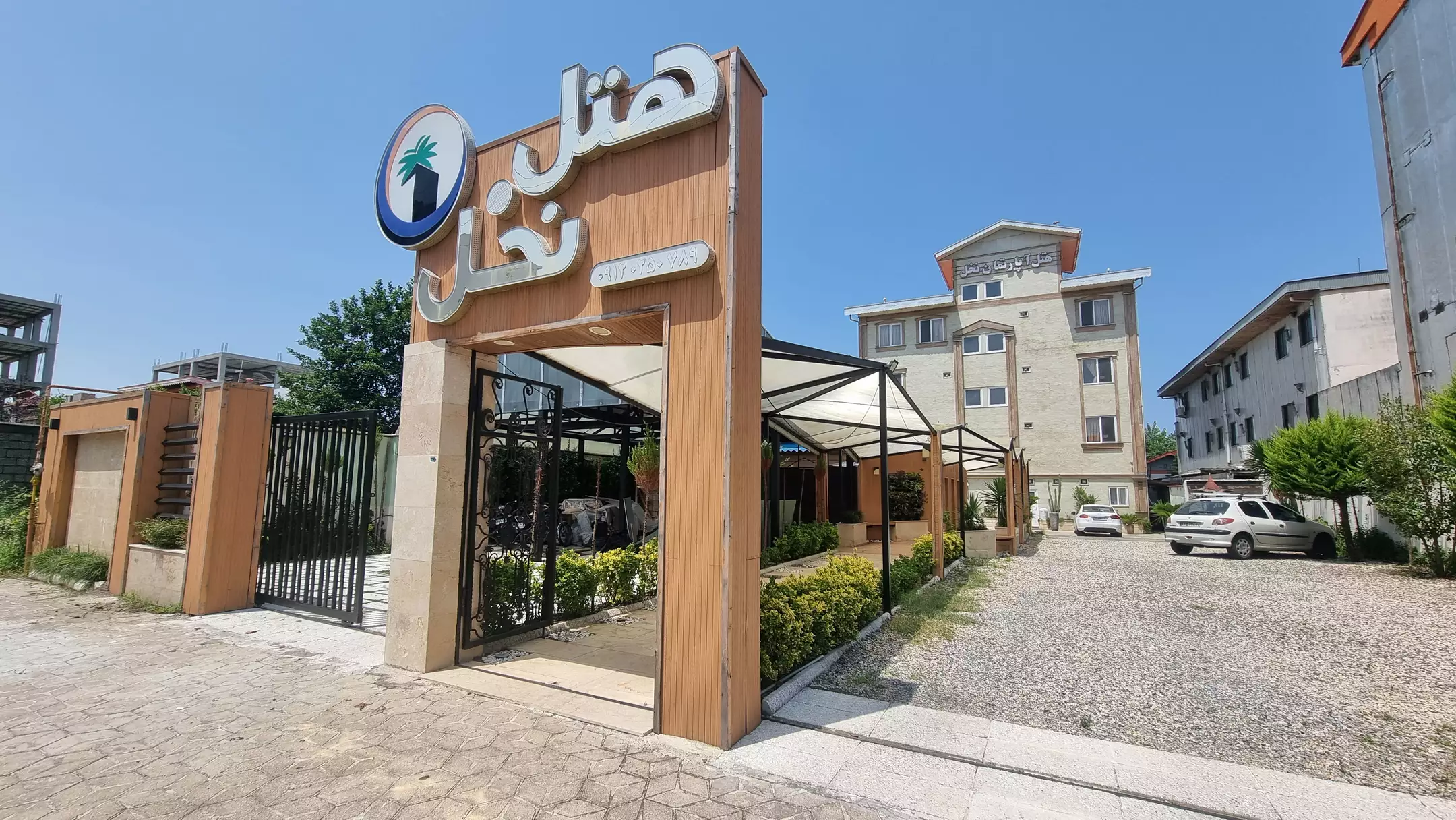 ورودی هتل نخل با سردر چوبی و محوطه پارکینگ