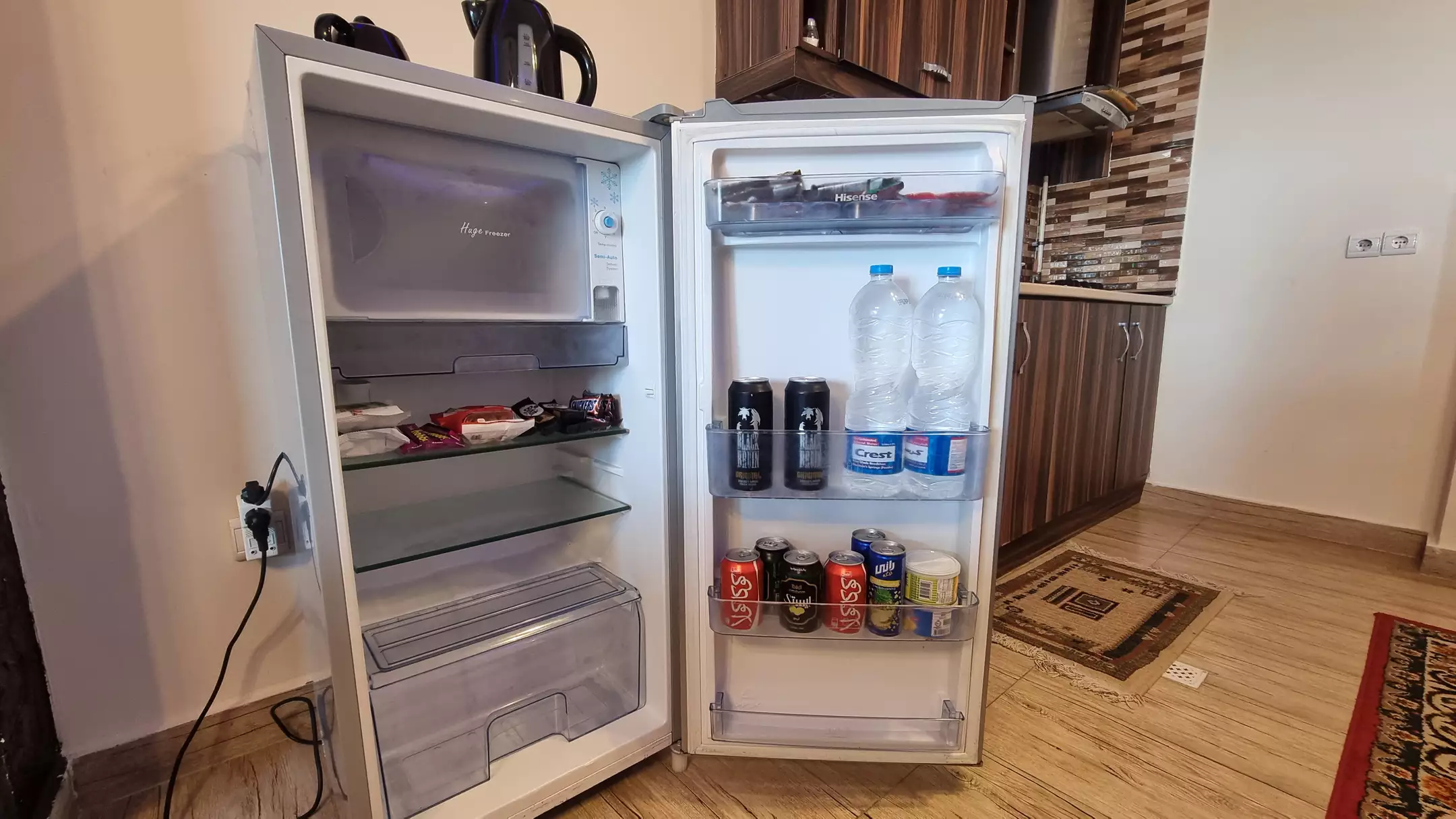 یخچال باز با بطری آب و نوشیدنی در اقامتگاه نخل