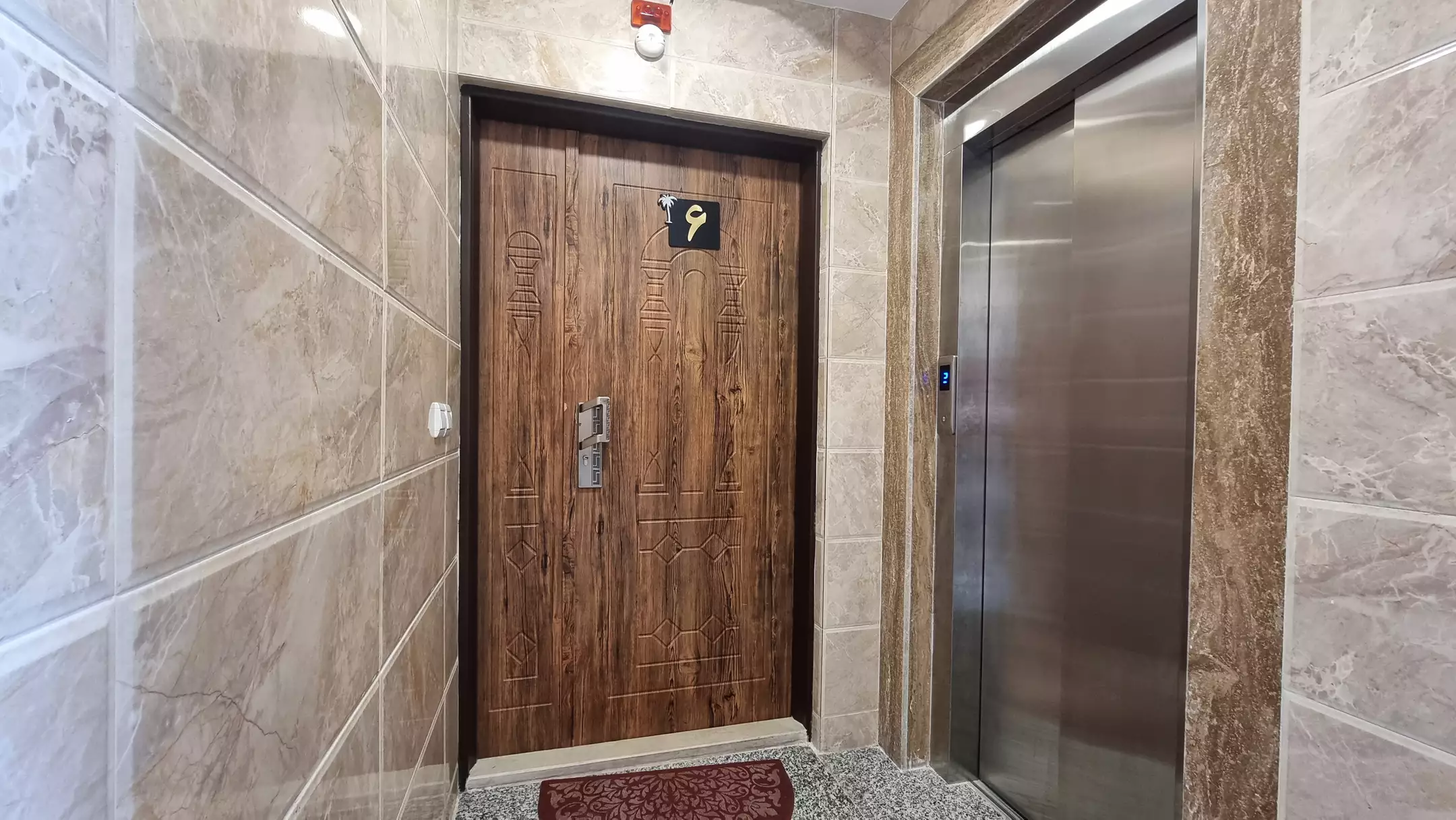 درِ چوبی اتاق کنار آسانسور هتل نخل