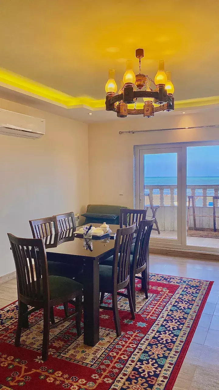 میز غذاخوری کنار پنجره رو به دریا در هتل نخل