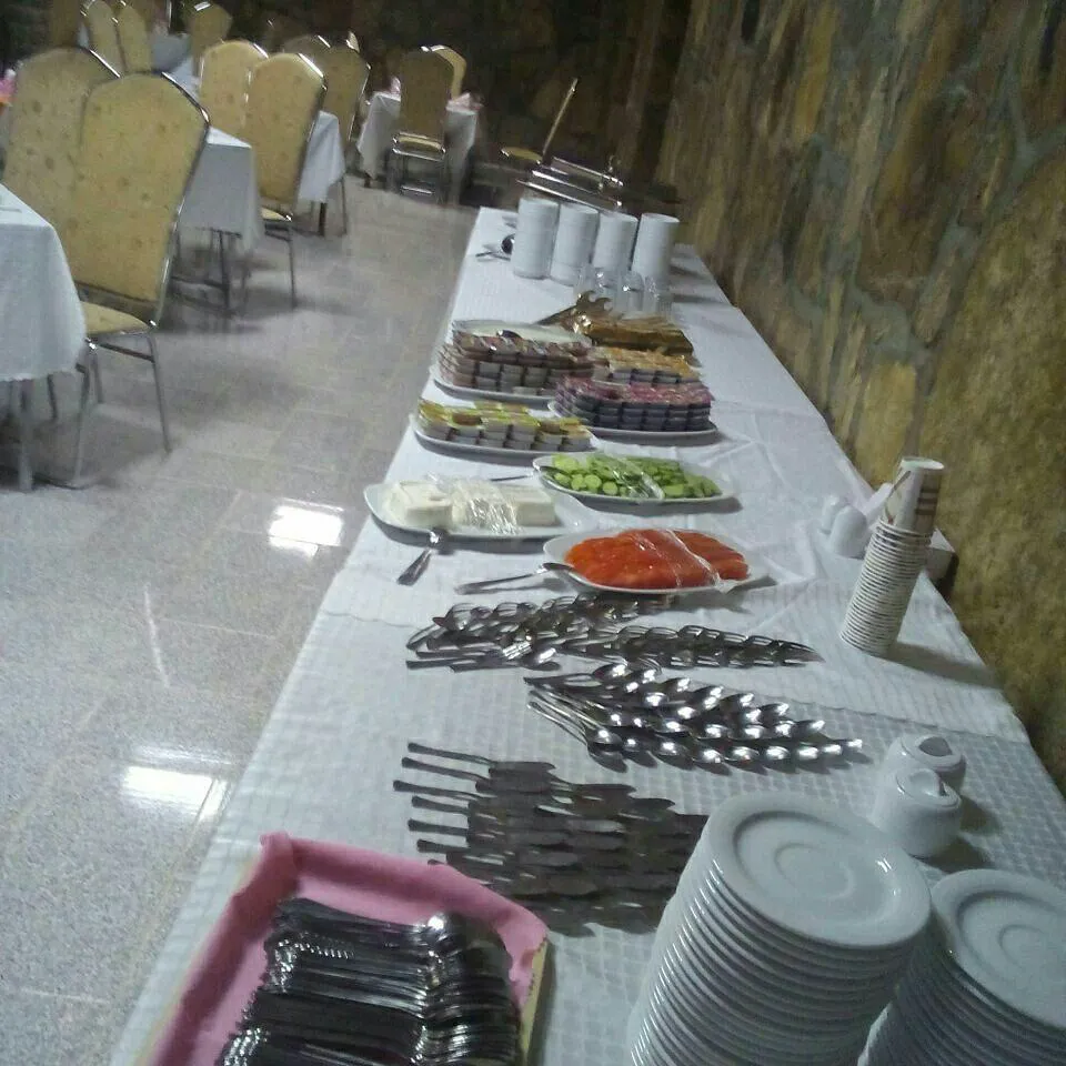 میز بوفه با غذا و ظروف در هتل شادی