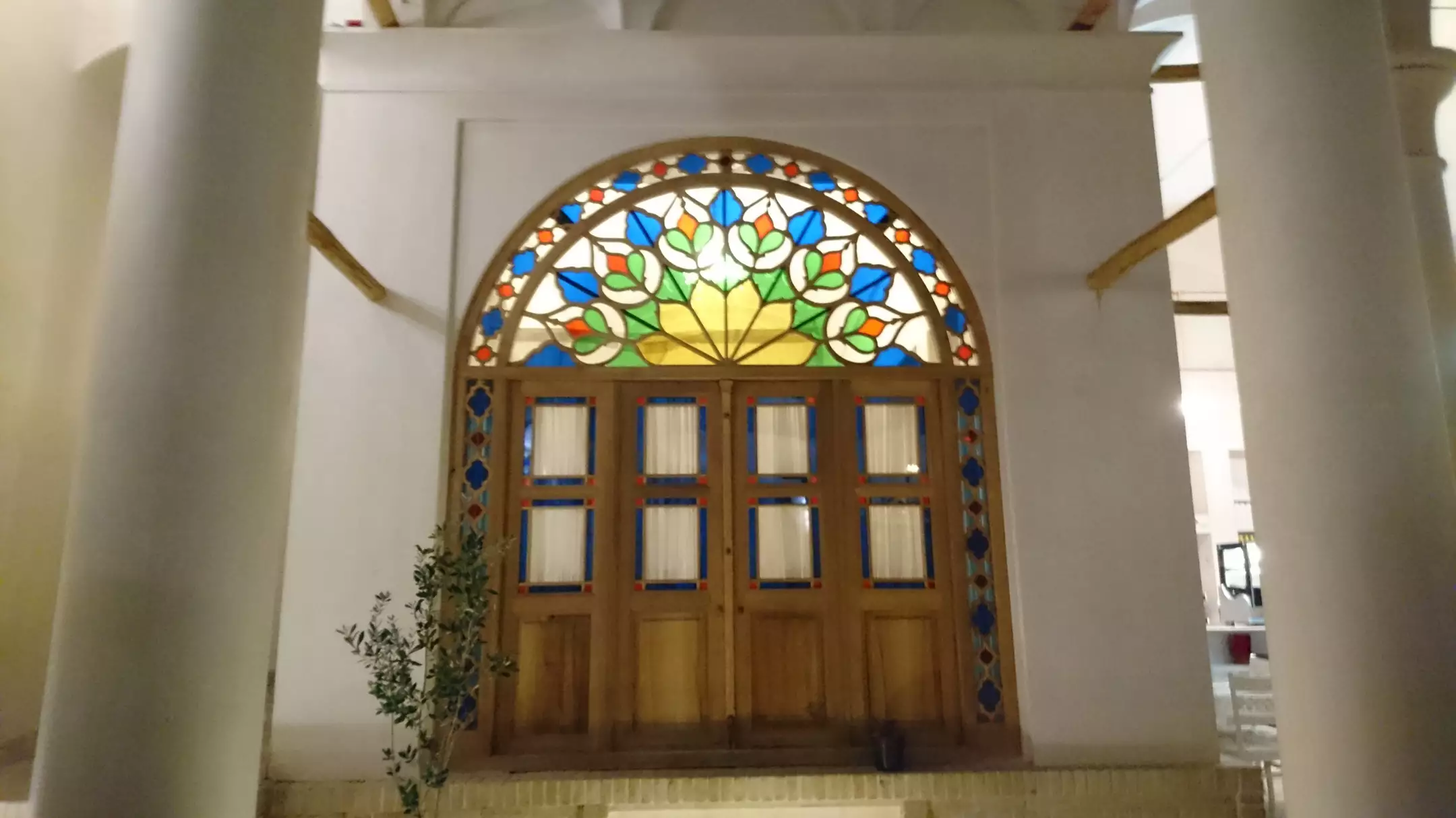 در چوبی آریانا با پنجره رنگی قوسی