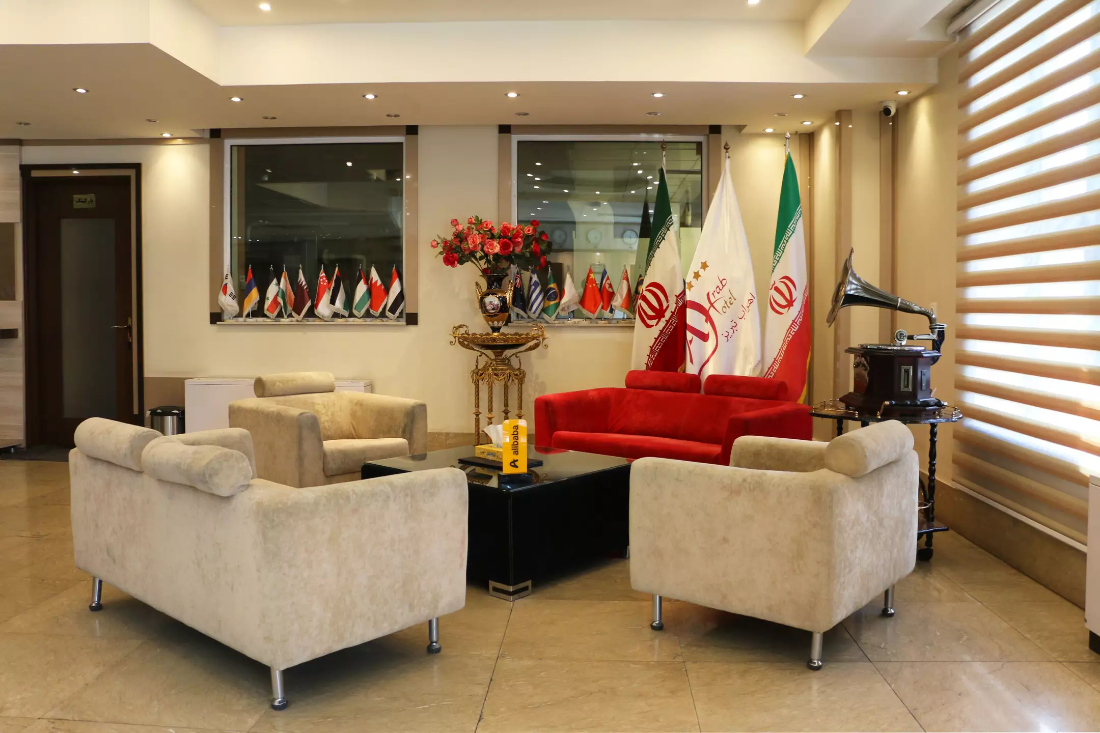 لابی هتل اهراب با مبل‌های کرم و پرچم‌های ایران