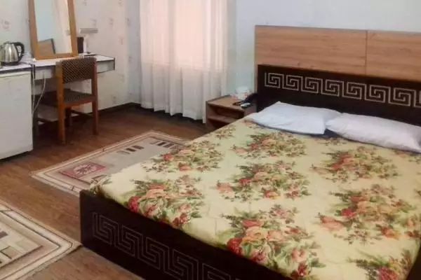 تخت دونفره با روتختی گلدار در هتل فروغ