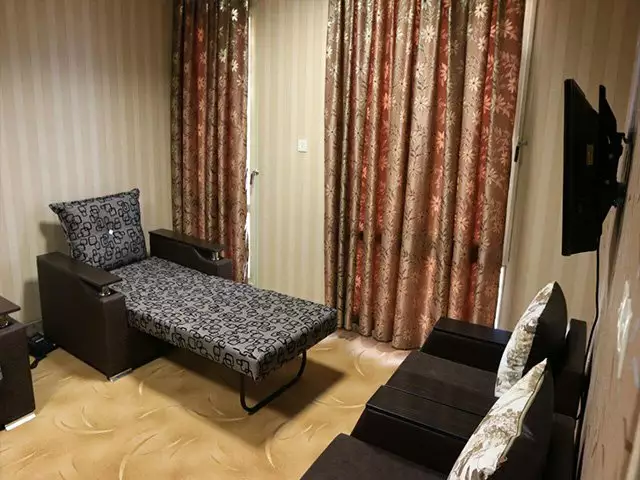 نشیمن اتاق با کاناپه و تلویزیون هتل ورزش