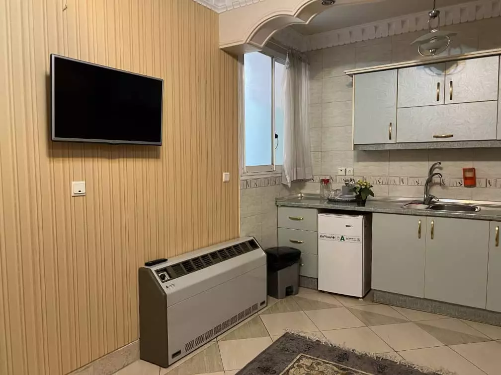 آشپزخانه هتل قصر با کابینت و یخچال کوچک