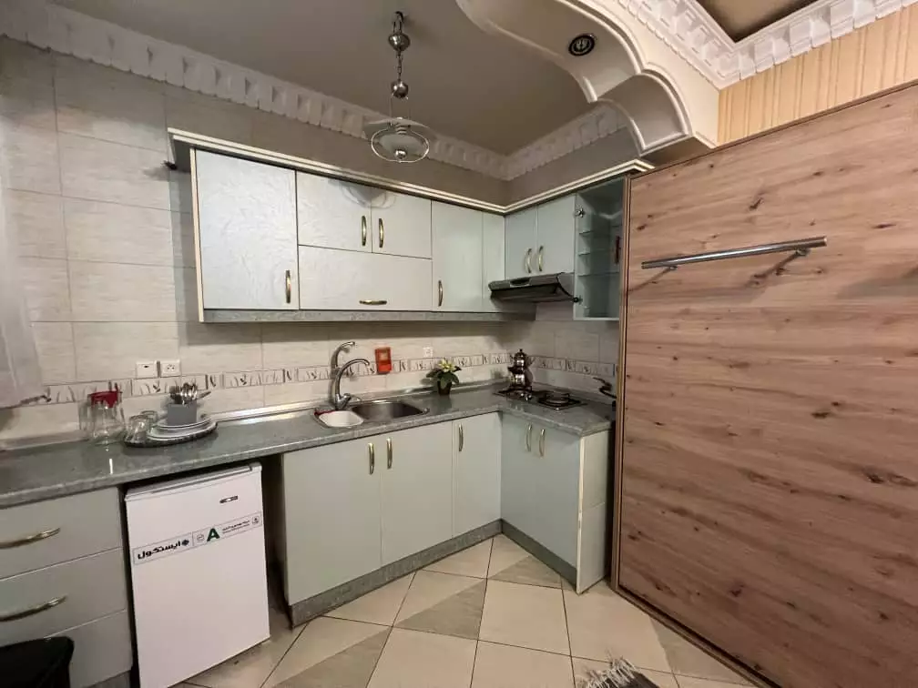 آشپزخانه هتل قصر با کابینت‌های روشن و سینک