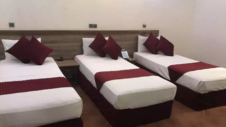سه تخت هتل جهانگردی با روتختیهای زرشکی