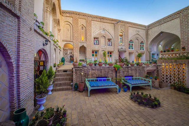 حیاط آجری و تخت‌های سنتی هتل طبیب شوشتری