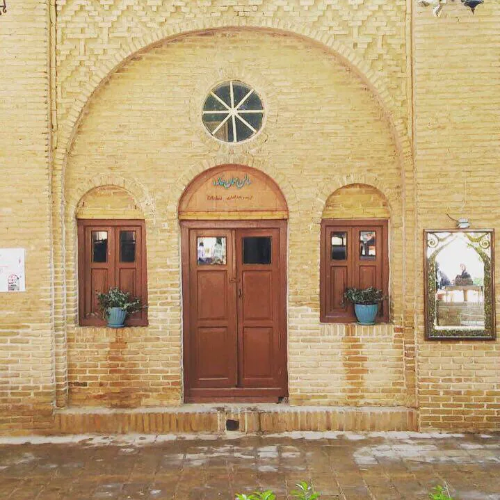 نمای ورودی آجری عمارت افضل با در چوبی