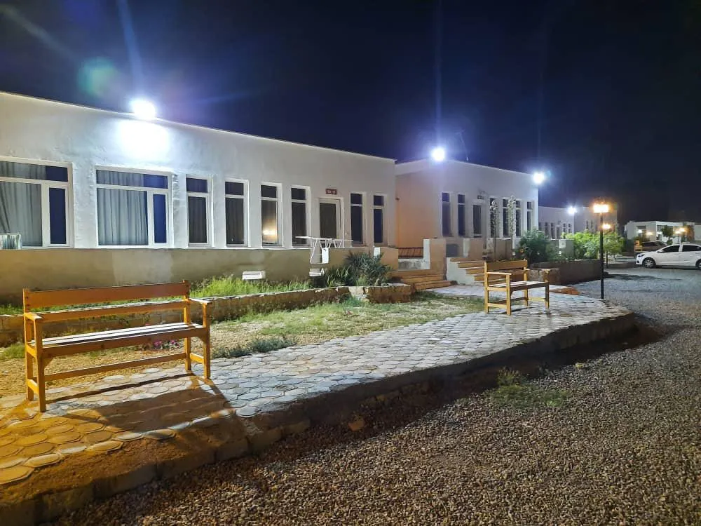 ساختمان و نیمکت‌های محوطه باغ ایران زمین در شب