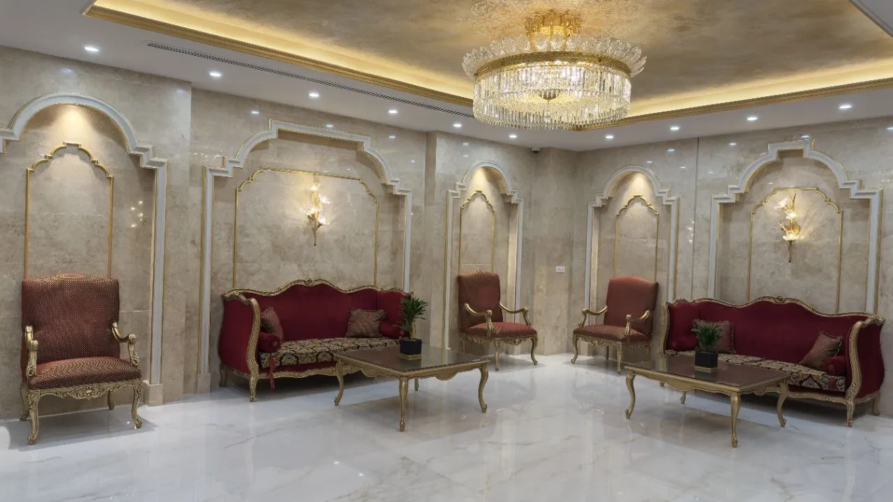 سالن نشیمن هتل بشری با مبلمان زرشکی و لوستر