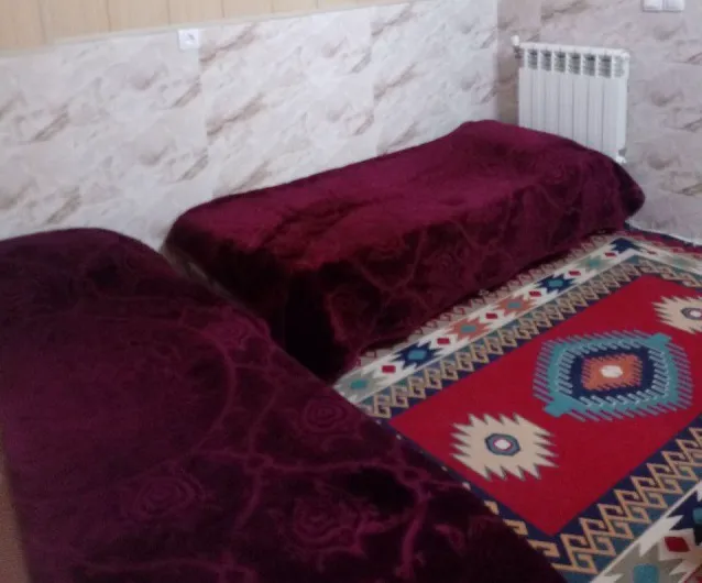 دو تخت با روتختی زرشکی و قالی سنتی هتل حیدری