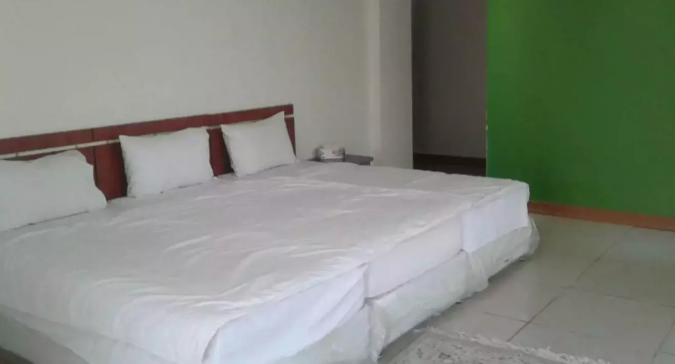 تخت دونفره سفید در اتاق هتل نیلوفر