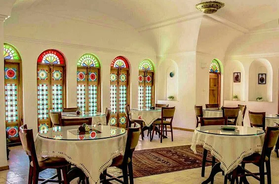 سالن غذاخوری تاریخی خانه آقازاده با پنجره‌های رنگی