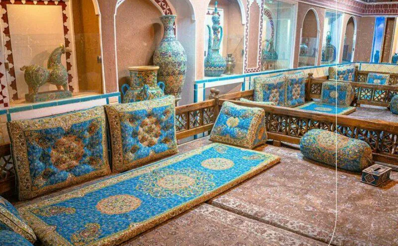 چیدمان سنتی با فرش و پشتی‌های فیروزه‌ای