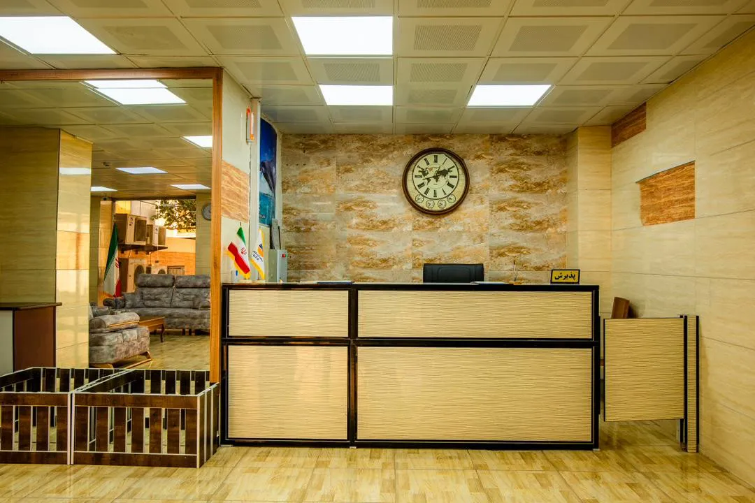 پذیرش هتل توس با پیشخوان چوبی و ساعت دیواری