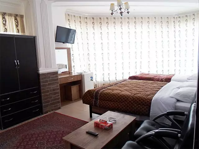 اتاق هتل افشار با تخت دونفره و تلویزیون دیواری