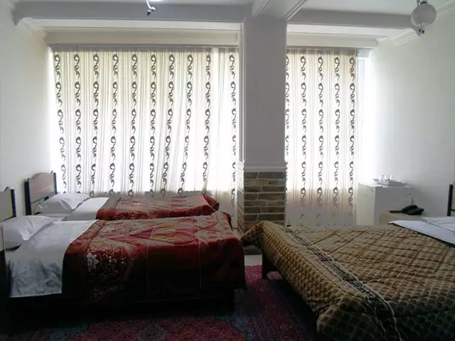 اتاق هتل افشار با تختهای دونفره و پرده طرحدار