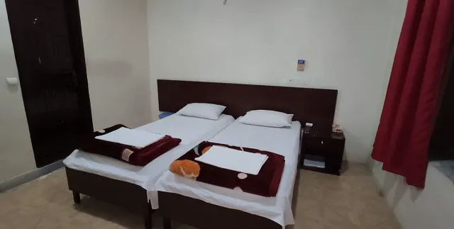 دو تخت یک‌نفره در اتاق هتل پردیسان