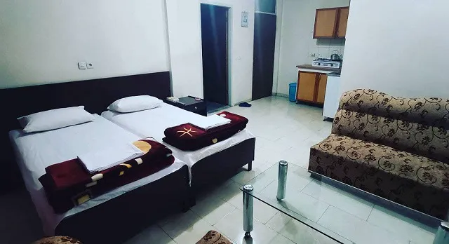 دو تخت و کاناپه در اتاق هتل پردیسان