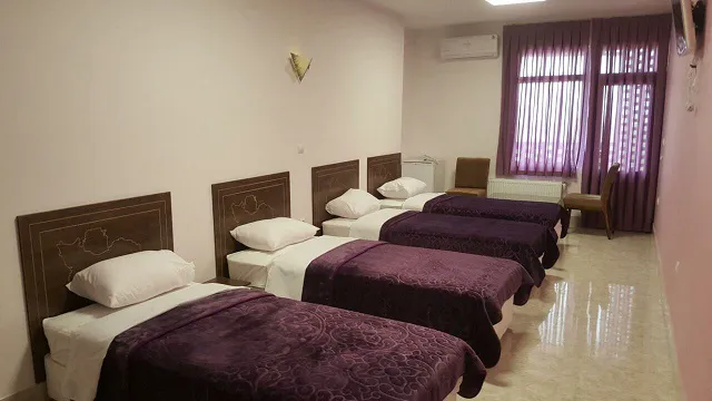 اتاق سه‌تخته هتل ایران زمین با روتختی‌های بنفش