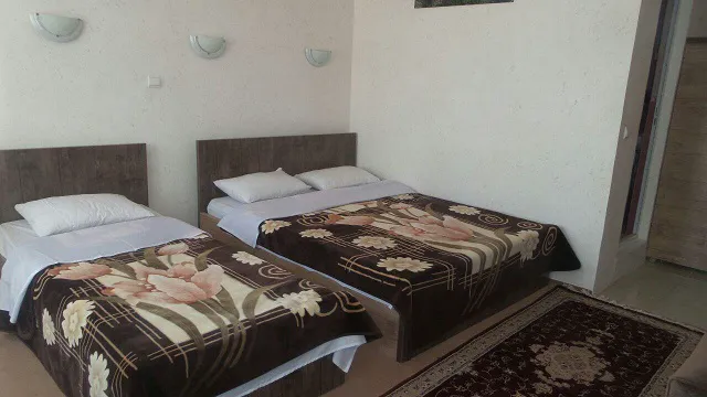 اتاق هتل ارم با دو تخت یکنفره و روتختی گلدار