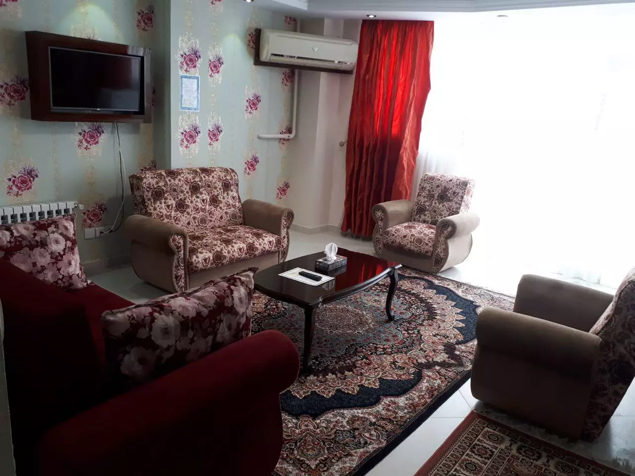 نشیمن هتل مدائن با مبلمان گل‌دار و فرش