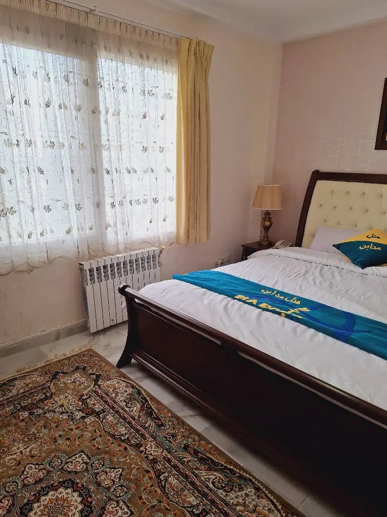تخت دونفره کنار پنجره اتاق هتل مدائن