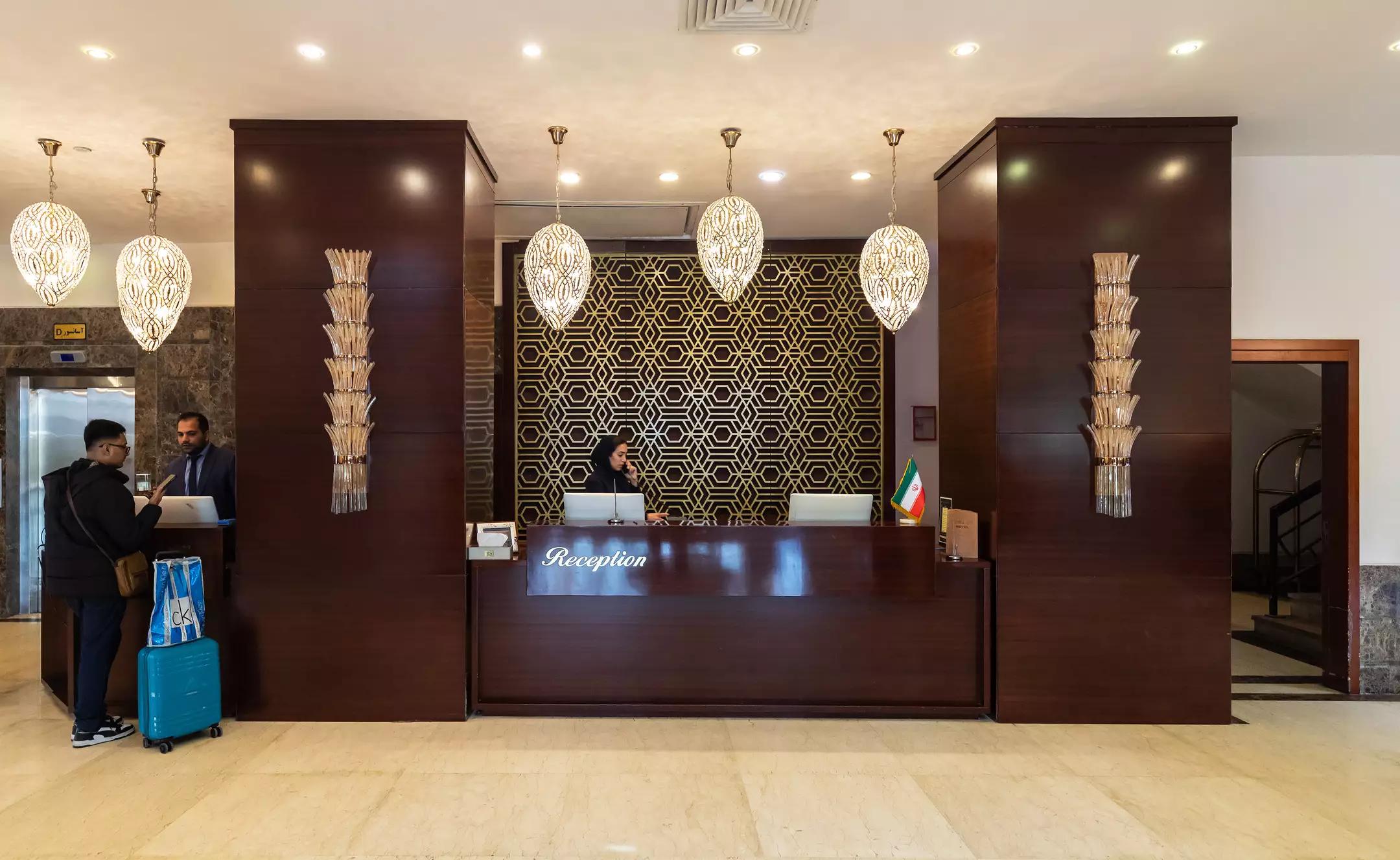 پذیرش هتل میراژ با پیشخوان چوبی و نقش هندسی