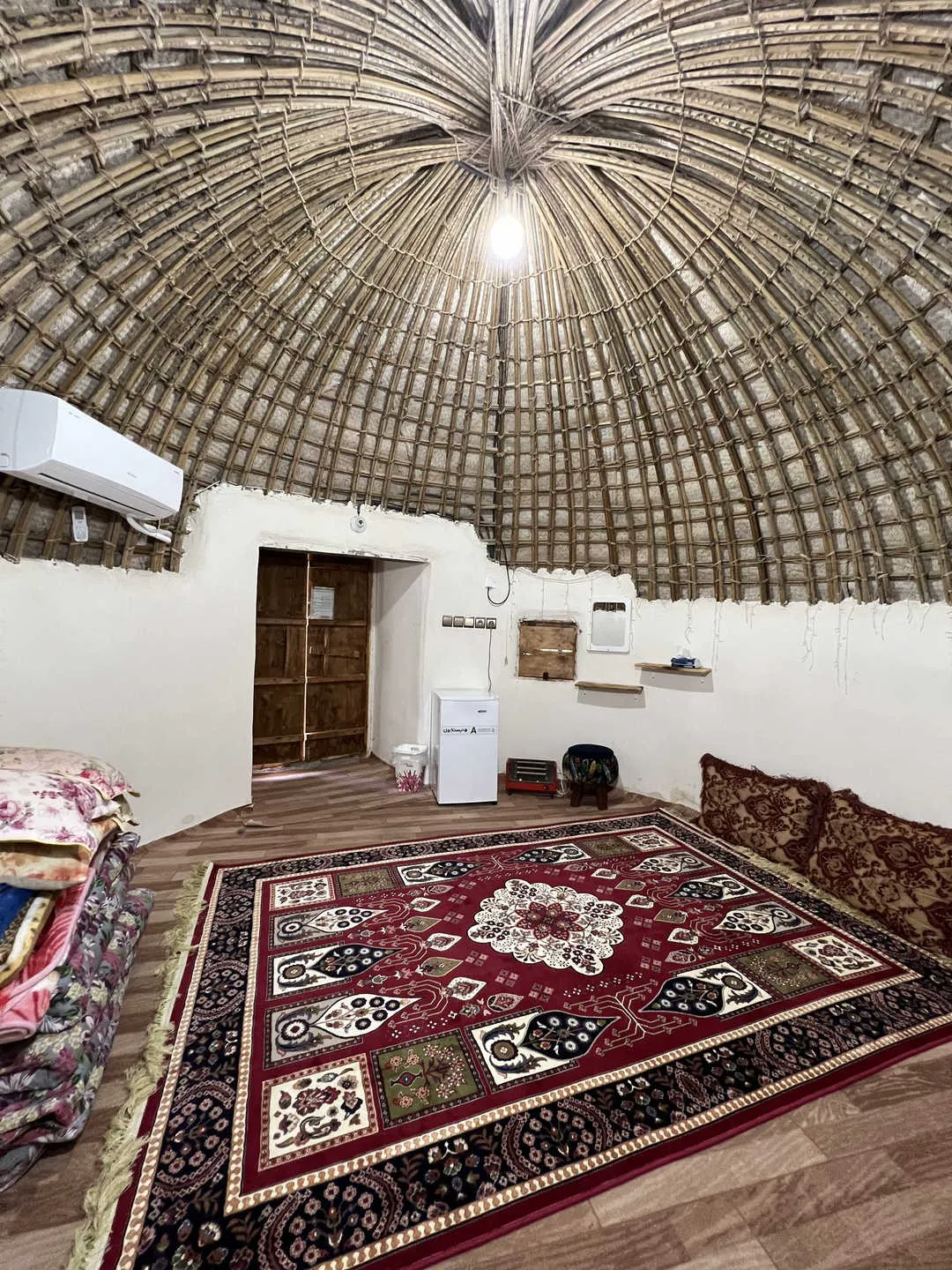 اتاق اقامتگاه فردیس با سقف گنبدی حصیری و فرش قرمز