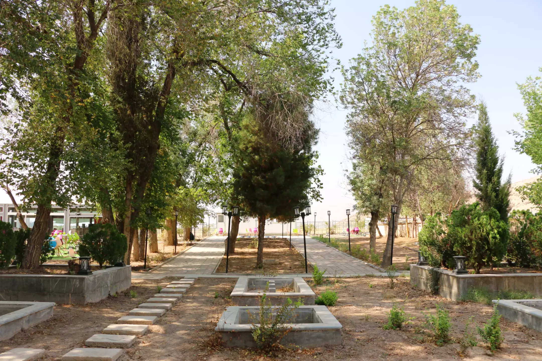 مسیر سنگ‌فرش‌شده میان درختان محوطه هتل آپادانا