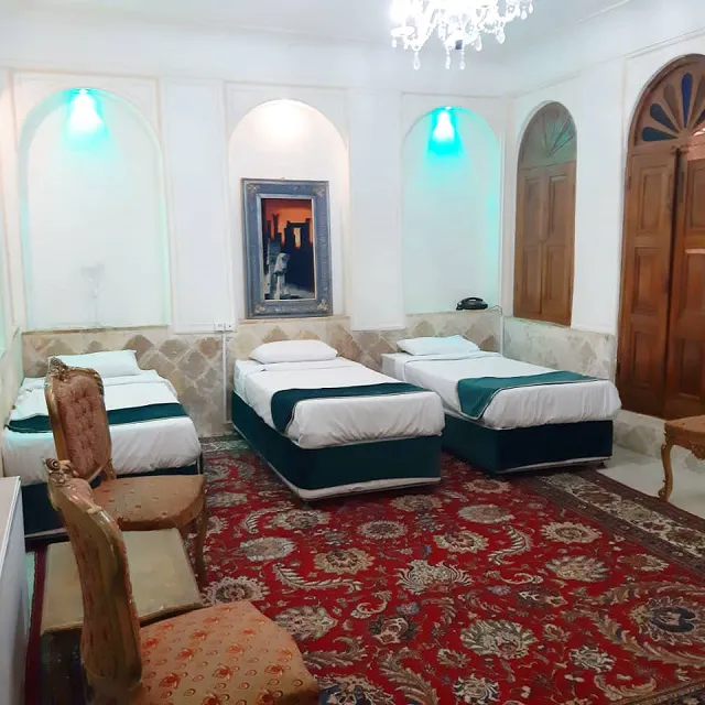 اتاق سهتخته هتل خان نشین با فرش قرمز و چراغهای دیواری