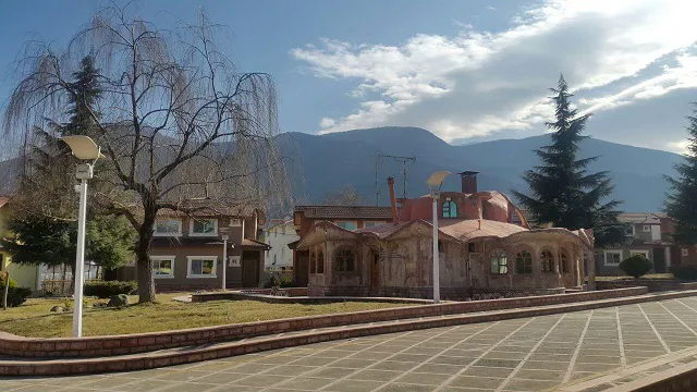 ساختمان گنبددار محوطه هتل پارسیان با کوهستان در پسزمینه
