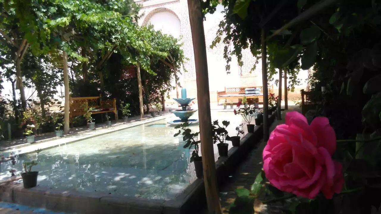 حوض آب و گل رز صورتی در حیاط خادمی