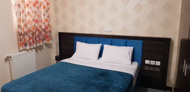 تخت دونفره با روتختی آبی در هتل سروناز