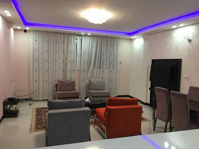 نشیمن هتل سروناز با مبل‌های رنگی و پرده بلند
