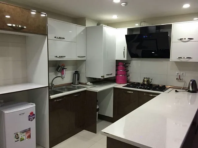 آشپزخانه هتل سروناز با کابینت سفید و اجاق گاز