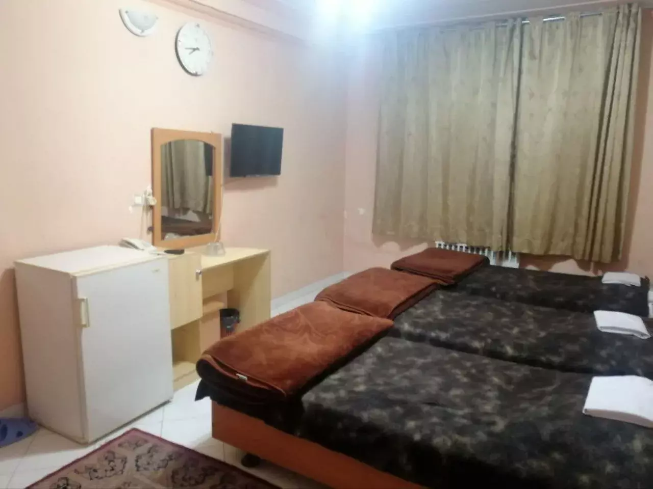 سه تخت یک‌نفره در اتاق هتل ناز